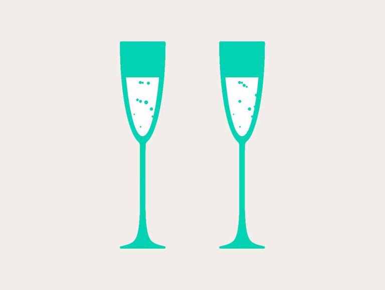 Two tall emerald green champagne glasses stand next to each other filled with a white and bubbly drink 